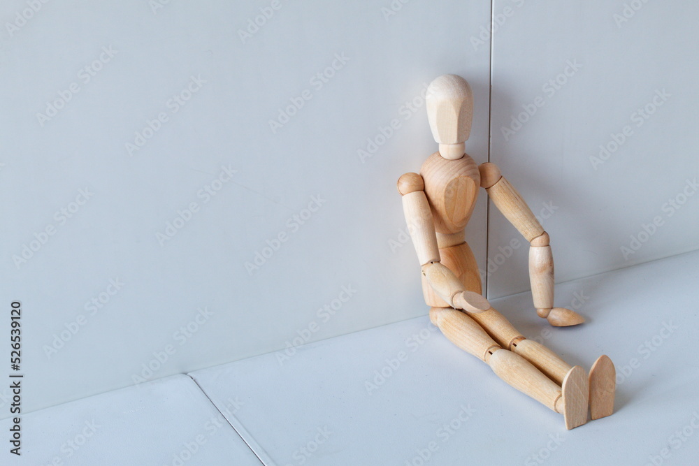 Concept of loneliness, poverty and abandonment with a wooden doll asking as a model Concept of loneliness, poverty and abandonment with a wooden doll asking as a model