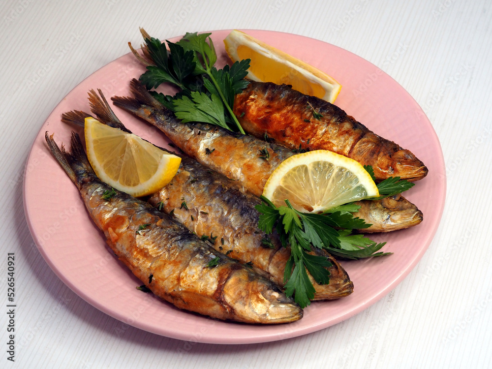 Plate with fried sardines on a white background Plate with fried sardines on a white background