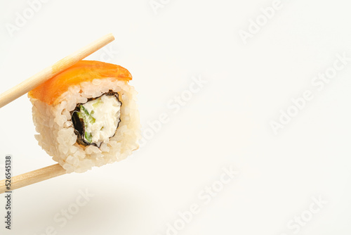 california sushi is held with wooden chopsticks on a white isolated background