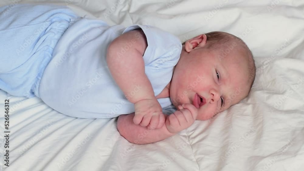 Closeup portrait of Newborn baby on white blanket. Soft focus. Infant is lying, yawning. One, two week age. Infant girl waking up on bed at home. New life and growing up concept. Real People. Closeup portrait of Newborn baby on white blanket. Soft focus. Infant is lying, yawning. One, two week age. Infant girl waking up on bed at home. New life and growing up concept. Real People.