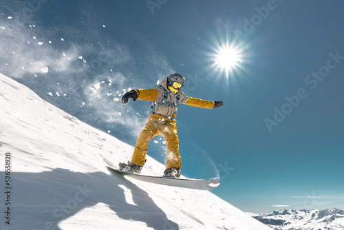 Real snowboarder jumps at alpine offpiste ski slope. Winter sports concept photo