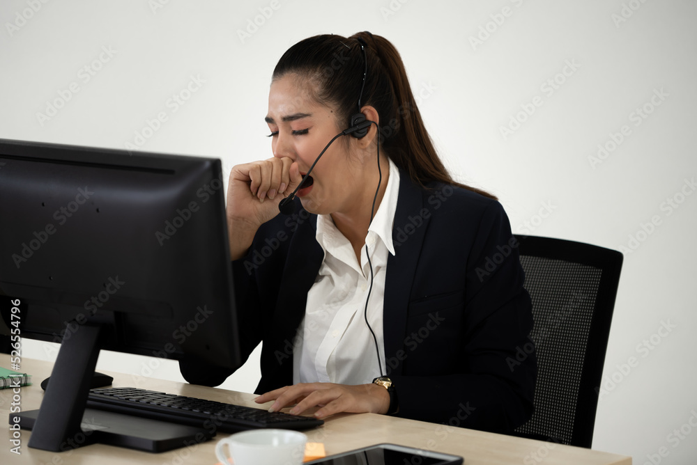 Young Asian business woman yawning at work. Young Asian business woman yawning at work.