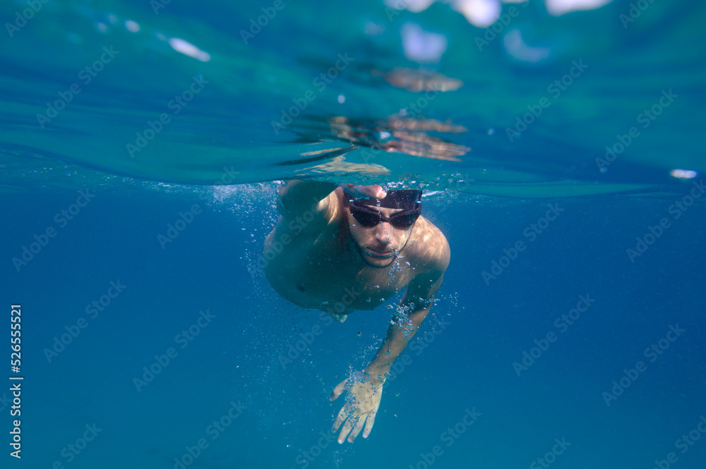 Sporty man swims fast in the sea