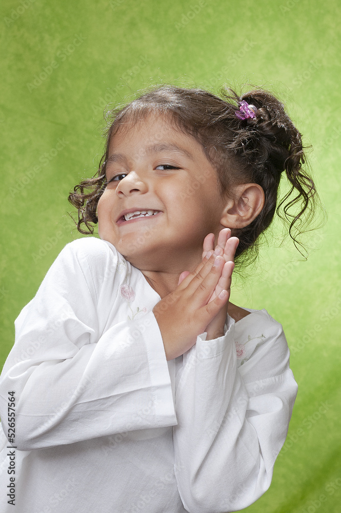 Divertida niña de 4 años haciendo gestos posando en estudio Stock Photo
