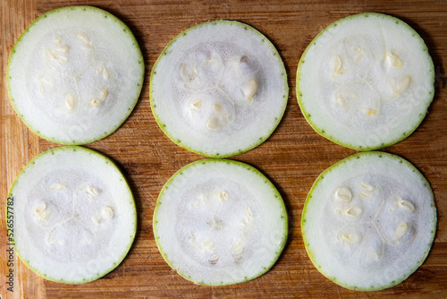 zucchini cut into circles on a wooden board