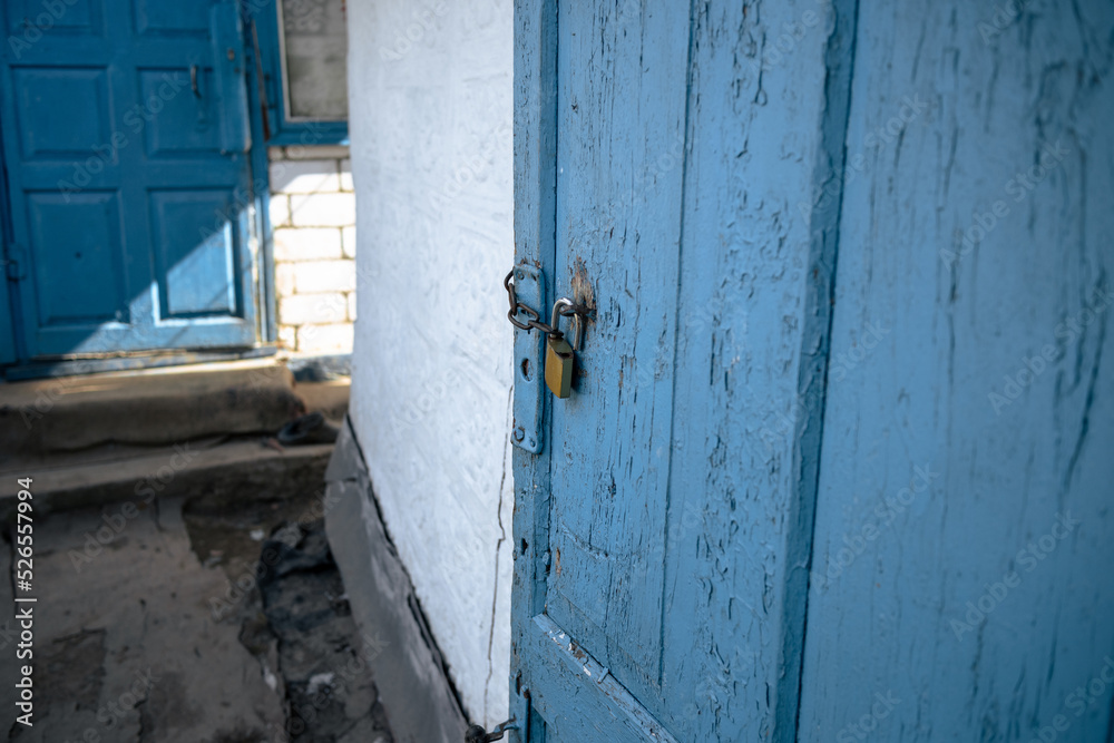 Old wooden barn door with a padlock. Padlock on an old blue wooden door