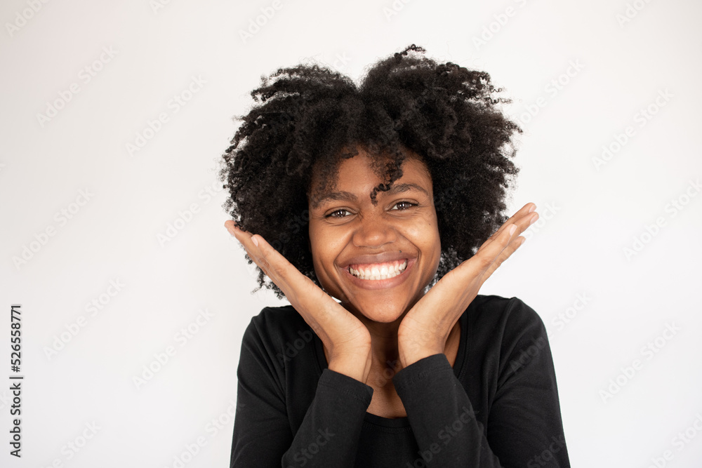 Close-up of happy young African American woman looking at camera. Face of excited young woman looking at camera and smiling against white background. Admiration concept Close-up of happy young African American woman looking at camera. Face of excited young woman looking at camera and smiling against white background. Admiration concept