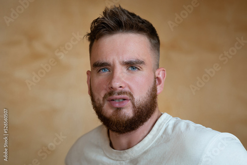 Portrait brutal handsome bearded man with blue eyes, male personal self care, products, accessory for growth style dark brown red beard. Lifestyle people