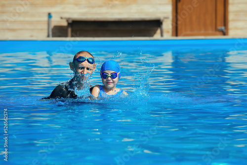 Swimming coach conducts an individual lesson with a little girl, the concept of a sports and healthy lifestyle for children