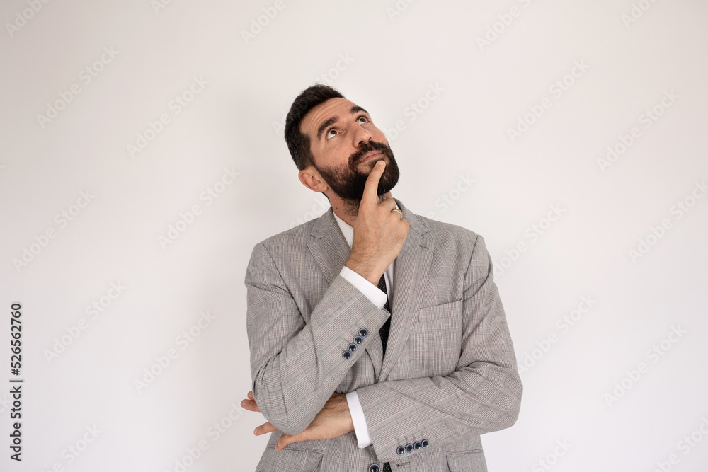 Portrait of considerate bearded man. Male model in suit against white background, thinking. Portrait, studio shot concept Portrait of considerate bearded man. Male model in suit against white background, thinking. Portrait, studio shot concept