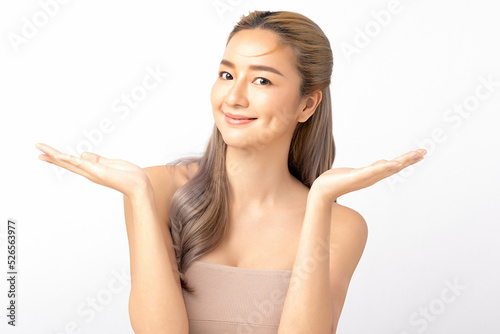 Happy beautiful asian woman looking to camera and showing empty copy space on the open hand. Asian girl beauty face skincare and health wellness, Facial treatment, Isolated on white background. 