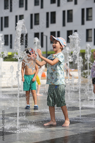 Child, fun kid. Summer water active children's games. Park, street in Moscow city, Russia. Improvement of public spaces. Summer fountain, rest, active children's games with water. Heat summer weather