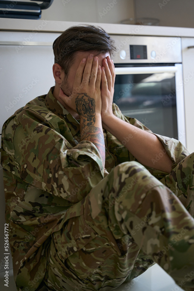 Soldier in despair covered his face with his hands