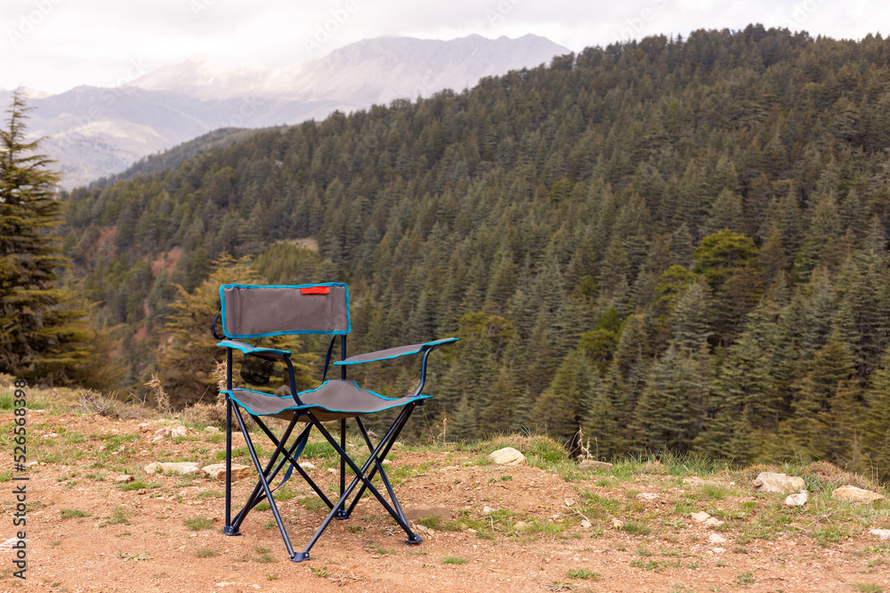 Empty camping chair with cedar forest view Empty camping chair with cedar forest view
