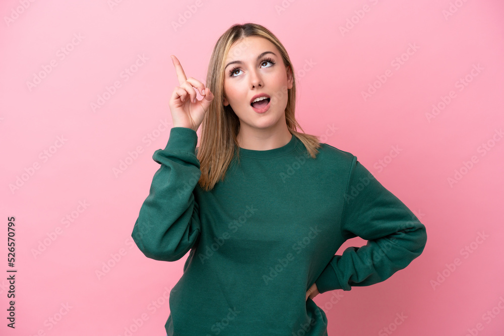 Young caucasian woman isolated on pink background intending to realizes the solution while lifting a finger up Young caucasian woman isolated on pink background intending to realizes the solution while lifting a finger up