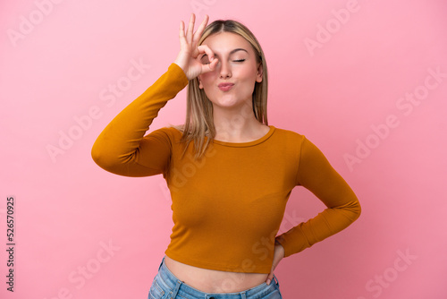 Young caucasian woman isolated on pink background showing ok sign with fingers © luismolinero