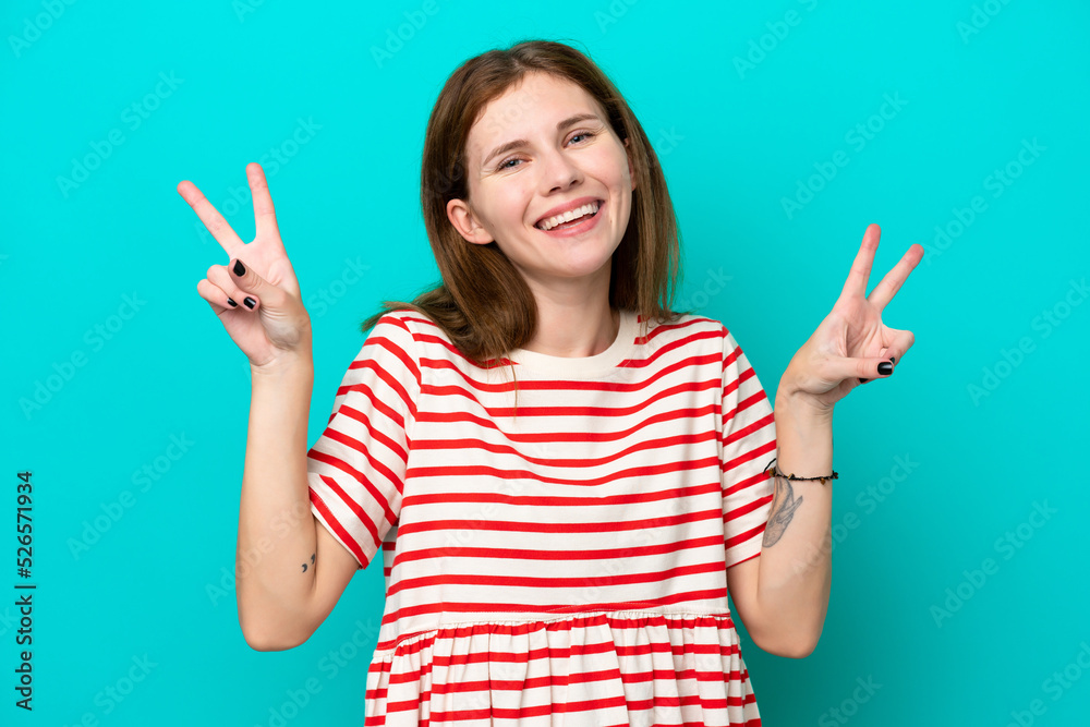 Young English woman isolated on blue background showing victory sign with both hands Young English woman isolated on blue background showing victory sign with both hands