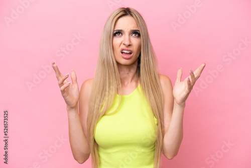 Pretty blonde woman isolated on pink background stressed overwhelmed