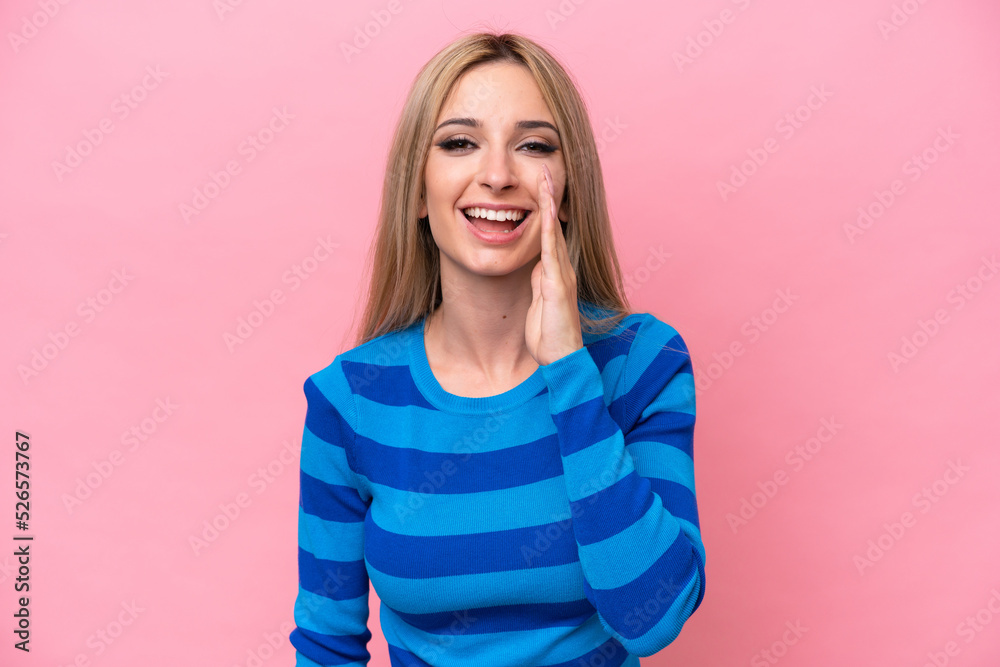 Fototapeta premium Pretty blonde woman isolated on pink background shouting with mouth wide open