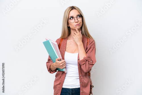 Pretty student blonde woman isolated on white background having doubts while looking up
