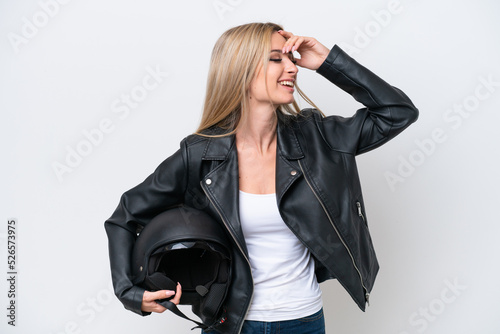 Pretty blonde woman with a motorcycle helmet isolated on white background smiling a lot