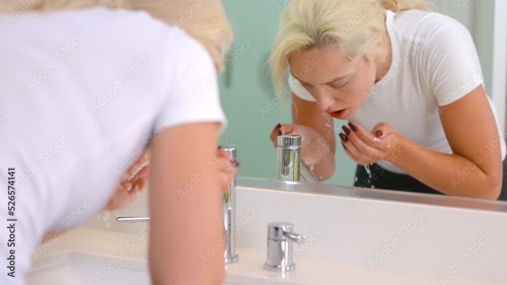 Attractive Latno woman washing her face in the bathroom sink. Slow motion. Attractive Latno woman washing her face in the bathroom sink. Slow motion.