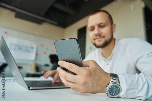 Man with laptop and phone working in the office