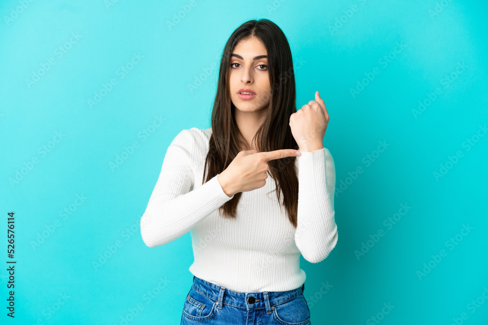 Young caucasian woman isolated on blue background making the gesture of being late Young caucasian woman isolated on blue background making the gesture of being late