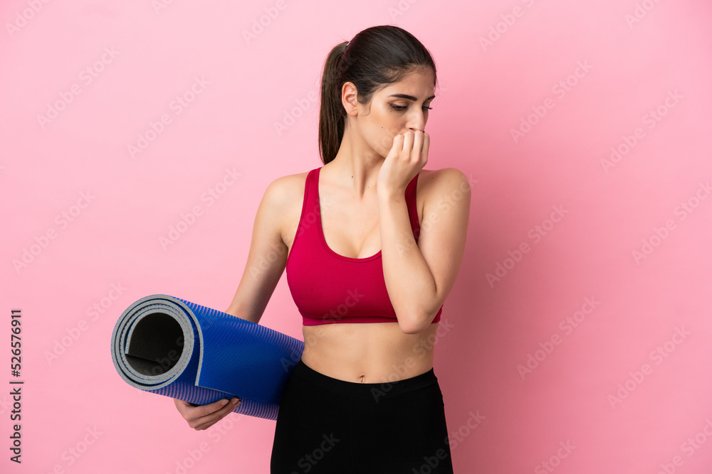 Young sport caucasian woman going to yoga classes while holding a mat having doubts Young sport caucasian woman going to yoga classes while holding a mat having doubts