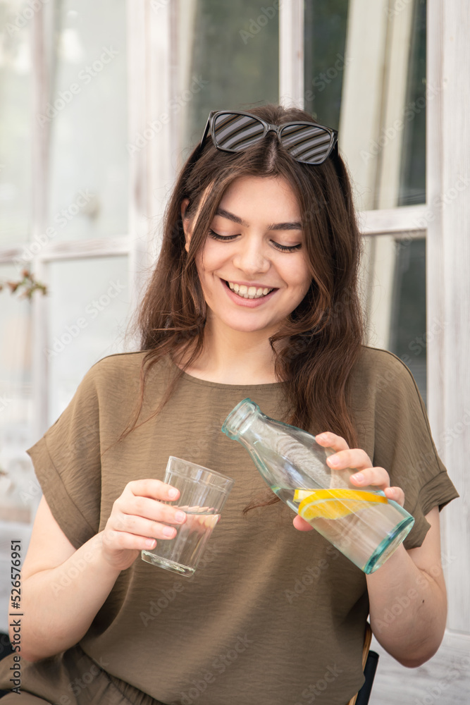 Attractive young woman drinks water with lemon. Attractive young woman drinks water with lemon.