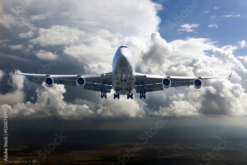 Front view of the passenger plane in flight. Thunderclouds in the aircraft background.