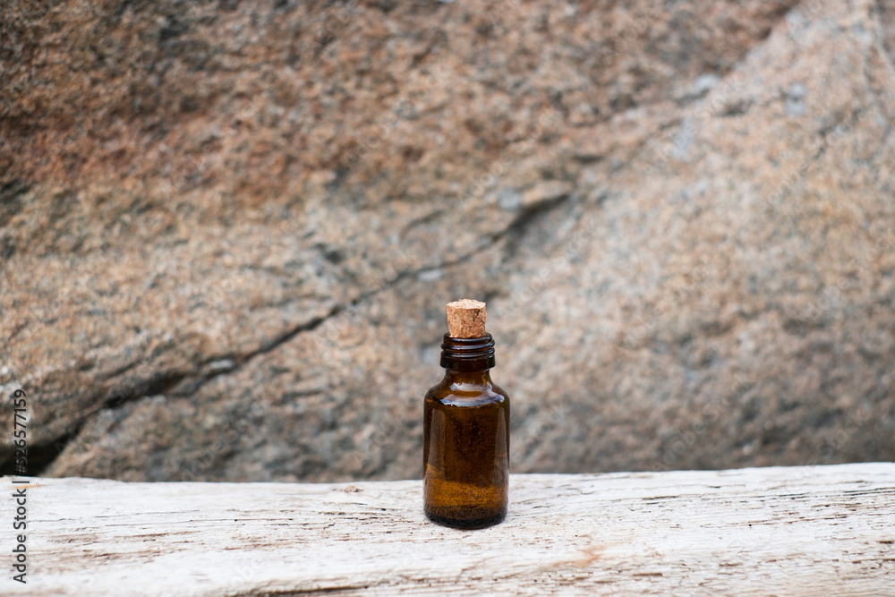 Small brown glass medicine bottle on aged wood background. Essential oil. Small brown glass medicine bottle on aged wood background. Essential oil.