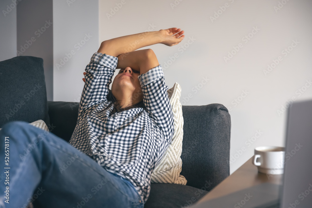 Fototapeta premium Tired from work young woman in front of a laptop.