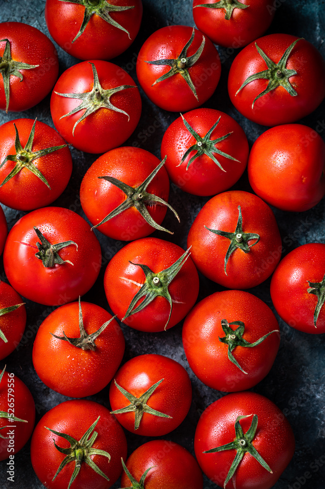 Many fresh red tomatoes on a dark green background. Top view Many fresh red tomatoes on a dark green background. Top view