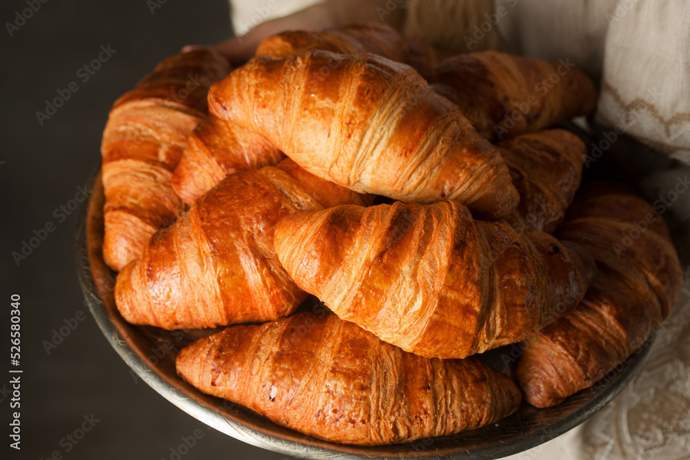 croissants on a tray in female hands croissants on a tray in female hands