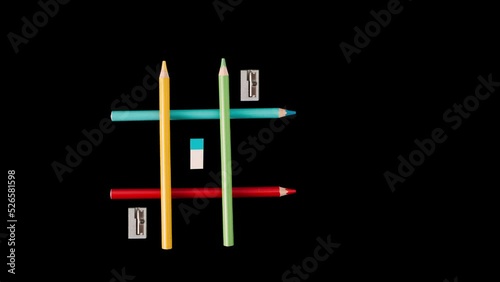 Game Iks Oks, wooden colored pencils, cutter, eraser. , concept of going to school, on black background, video animation 4K photo