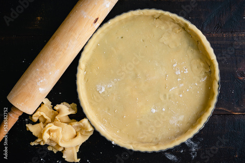 Tart Pan Filled with Raw Pastry Dough: Dough-filled tart pan with pastry crust scraps and a rolling pin