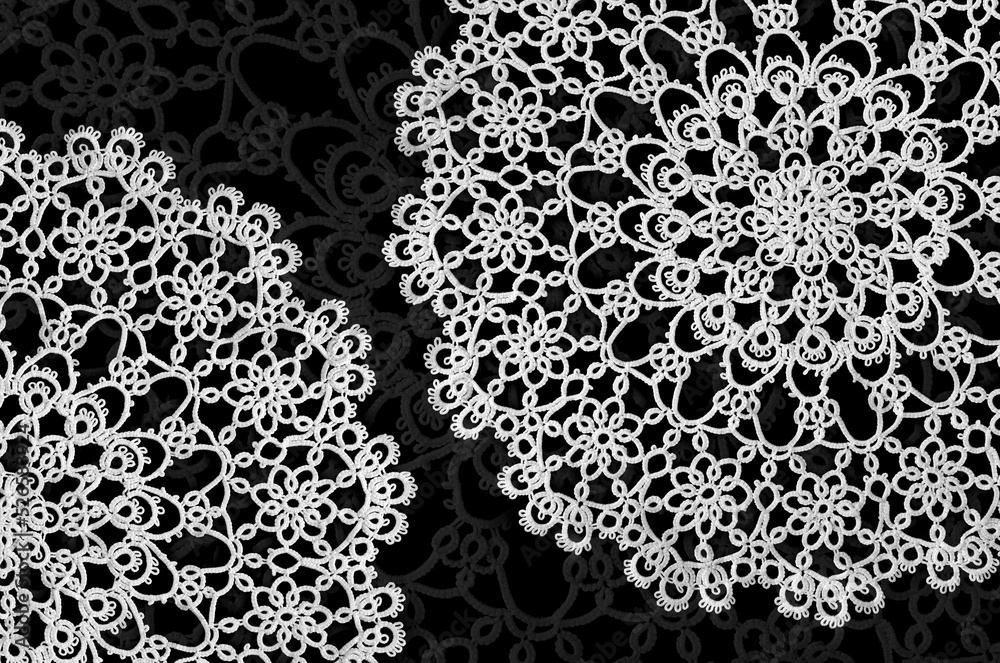 Detail of two old handmade doilies on a dark ornamental backdrop