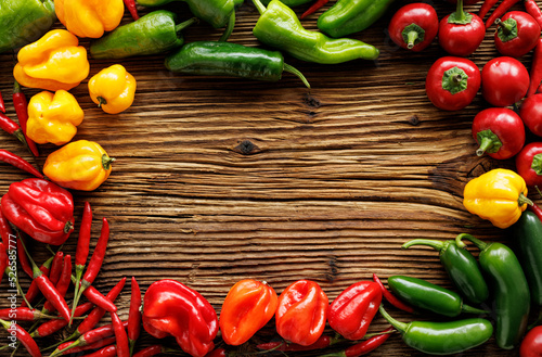 Background with assorted peppers on a wooden board with space for text