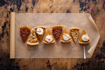 Variety of fall pie slices on parchment paper
