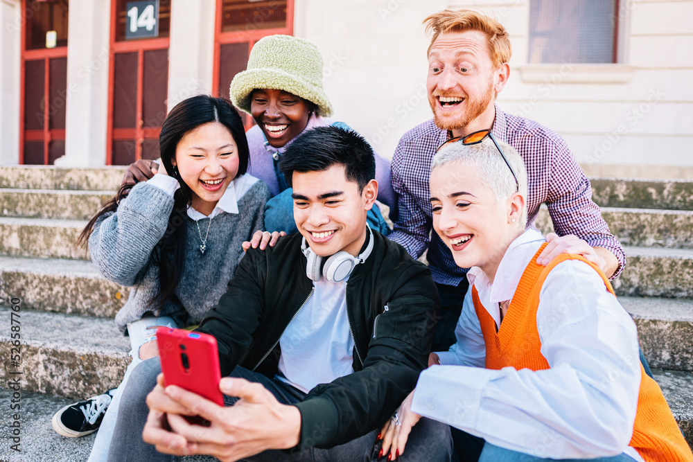 Obraz premium group taking a selfie photo with a smartphone sitting on the floor.