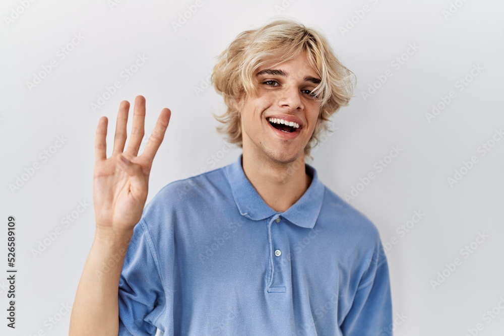 Young modern man standing over isolated background showing and pointing up with fingers number four while smiling confident and happy. Young modern man standing over isolated background showing and pointing up with fingers number four while smiling confident and happy.