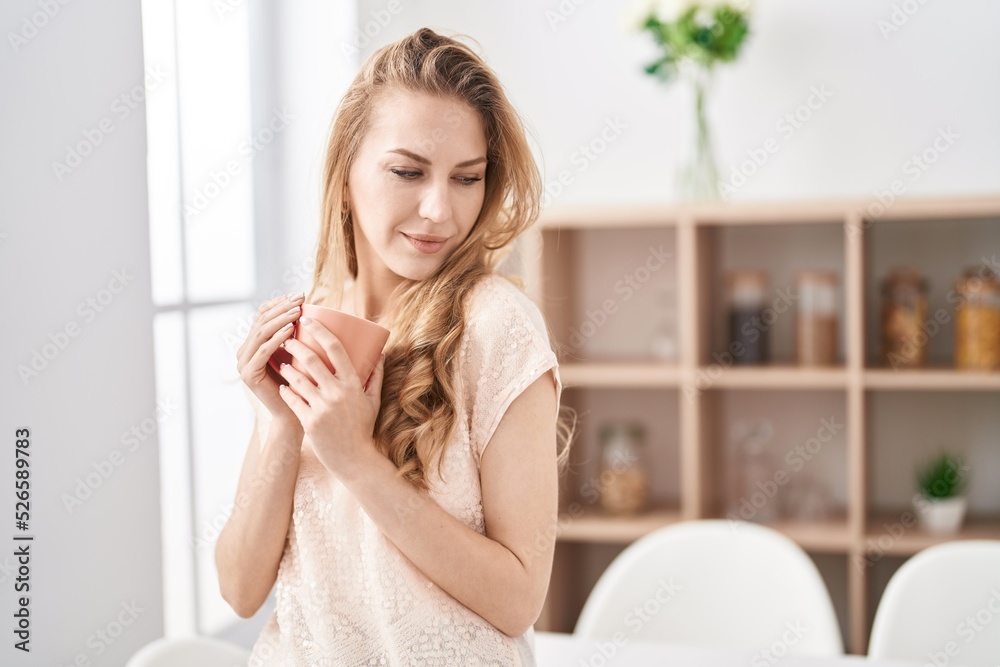 Young blonde woman smiling confident drinking coffee at home Young blonde woman smiling confident drinking coffee at home