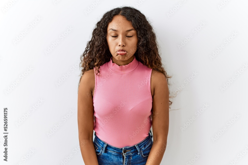 Beautiful hispanic woman standing over isolated background depressed and worry for distress, crying angry and afraid. sad expression. Beautiful hispanic woman standing over isolated background depressed and worry for distress, crying angry and afraid. sad expression.