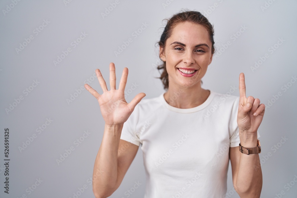 Beautiful brunette woman standing over isolated background showing and pointing up with fingers number six while smiling confident and happy. Beautiful brunette woman standing over isolated background showing and pointing up with fingers number six while smiling confident and happy.