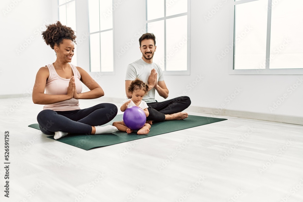 Couple and daughter smiling confident training yoga at sport center Couple and daughter smiling confident training yoga at sport center
