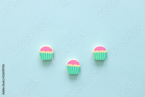 Colored wooden figures in the form of cakes on a blue background © ALEXSTUDIO