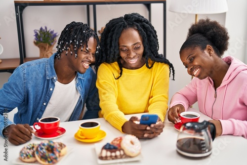 African american friends having breakfast and using smartphone at home