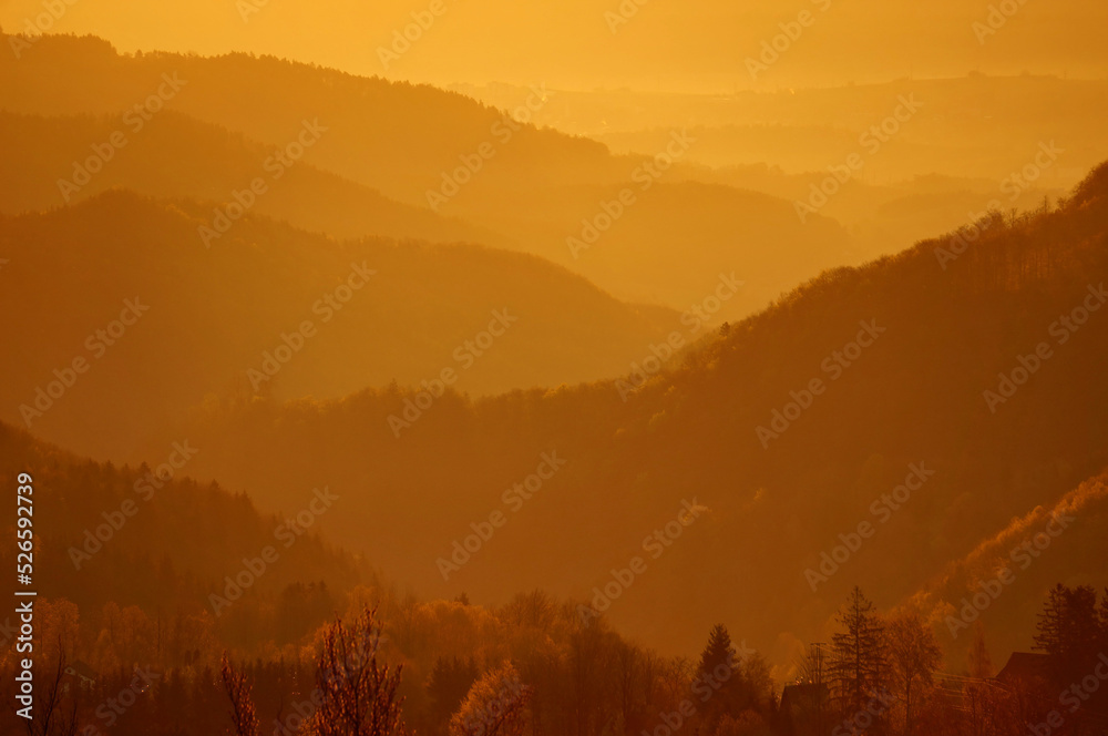 Hilly landscape around village Králiky in Slovakia in yellow light during moody early morning before sunrise