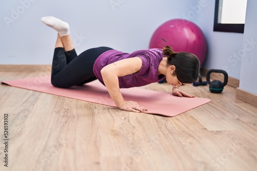 Young woman training push up at sport center